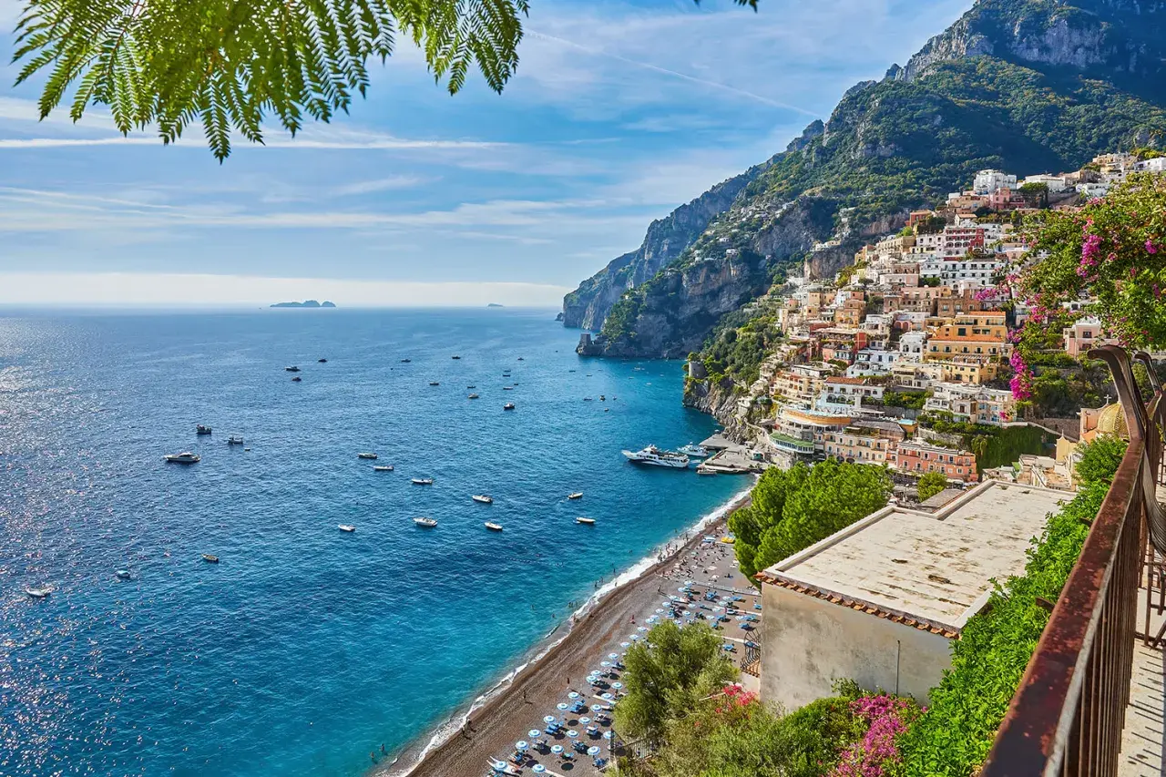 Positano, un luogo perfetto per un weekend con bambini in Campania. Case colorate aggrappate alla scogliera, mare blu e spiaggia animata.