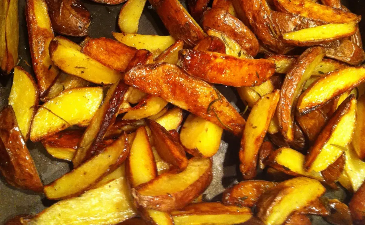 Krispiga klyftpotatis i ugn, gyllene och doftande av örter. Perfekt tillbehör som får det att vattnas i munnen.