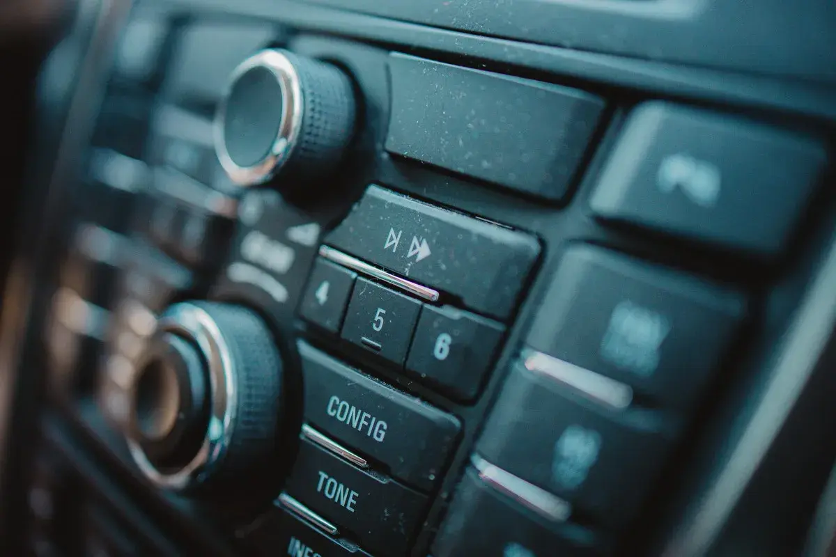 Dettaglio del pannello di un'autoradio, con manopole e pulsanti per il montaggio e la configurazione.