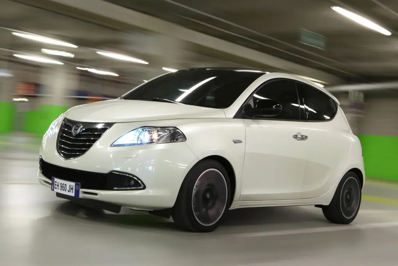 Lancia Ypsilon a metano in movimento in un parcheggio.