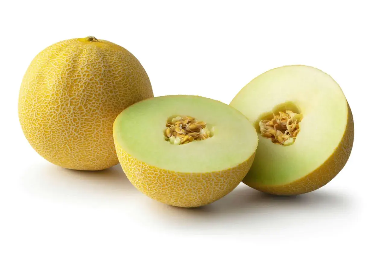 En hel och två halvor av en saftig cantaloupemelon med synliga kärnor. Perfekt för en svalkande sommardessert.