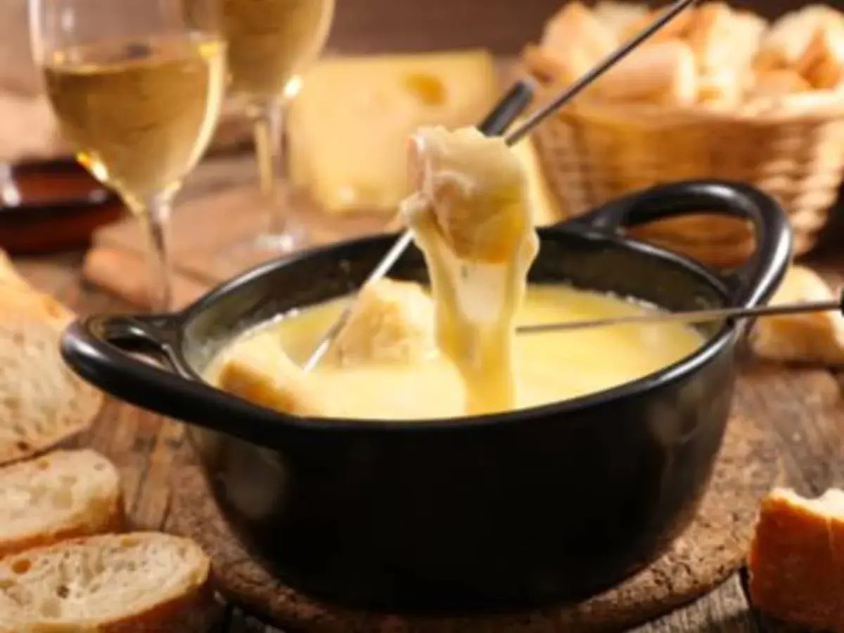 Une délicieuse fondue au beaufort, avec du pain croustillant et un verre de vin blanc.