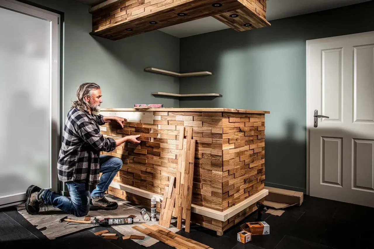 Mann baut mit Holzstücken eine einzigartige Bar. Heimwerken: bar selber bauen mit Stil.