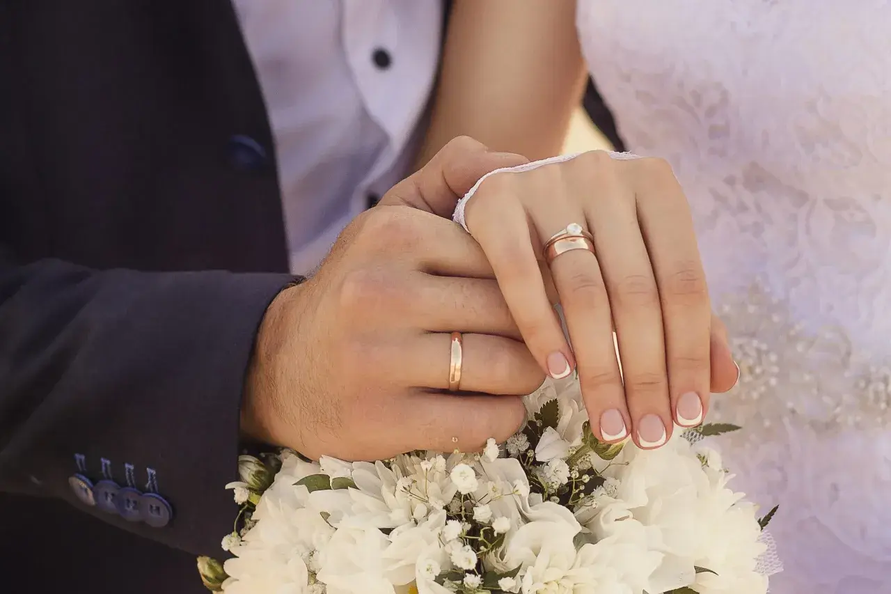 Manos entrelazadas con anillos de matrimonio. En España, el anillo de matrimonio se pone en la mano izquierda.