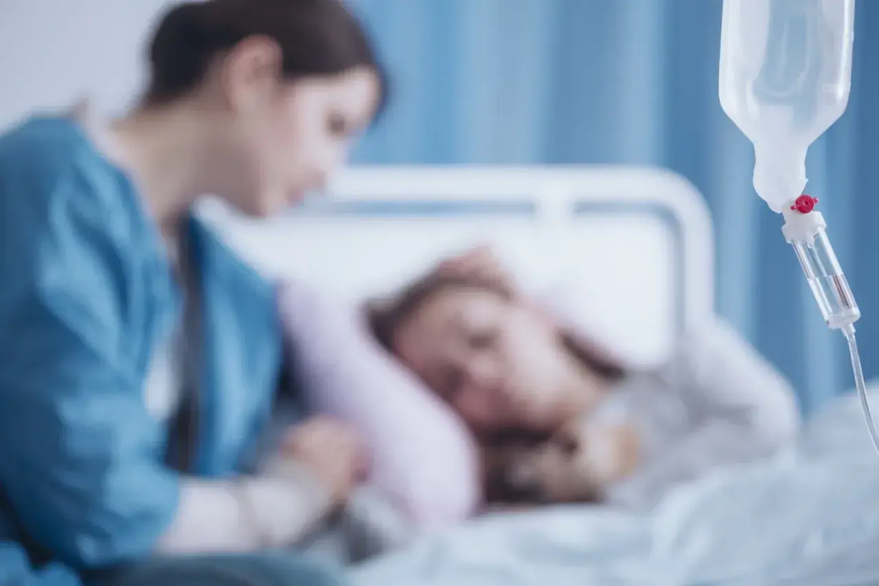 Pielęgniarka czuwa przy dziecku w szpitalu, które walczy z chorobą DMD. Kroplówka podtrzymuje życie.