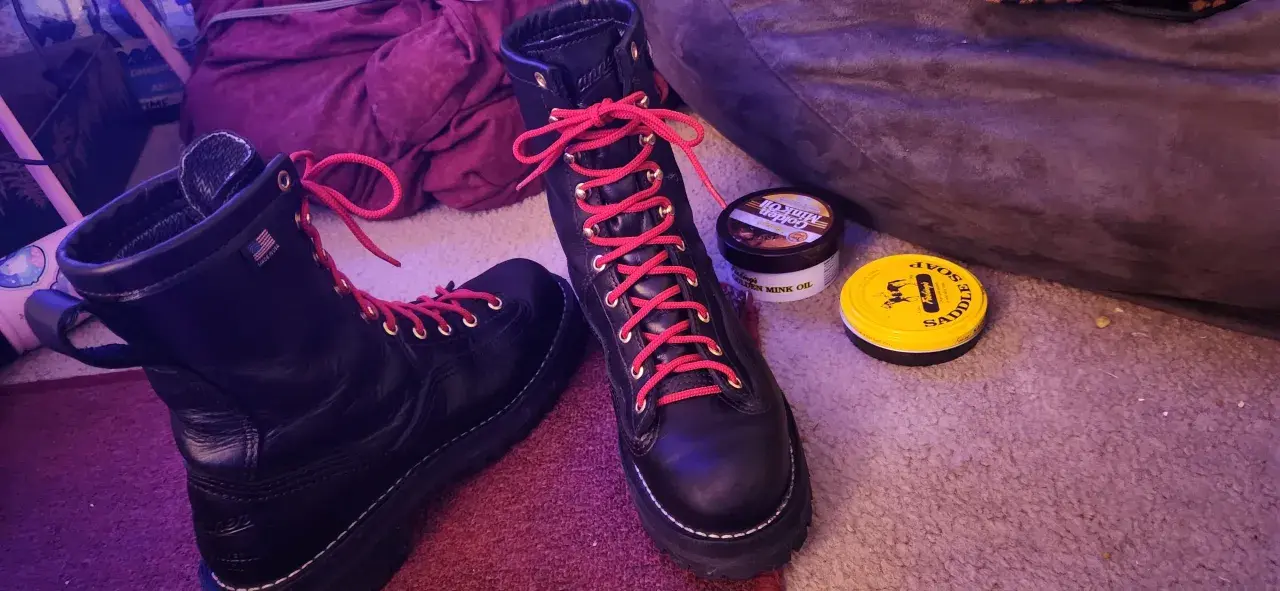 Black hiking boots with bright red laces, ready for adventure. Why do hiking boots have red laces? For a pop of color and to stand out on the trail!