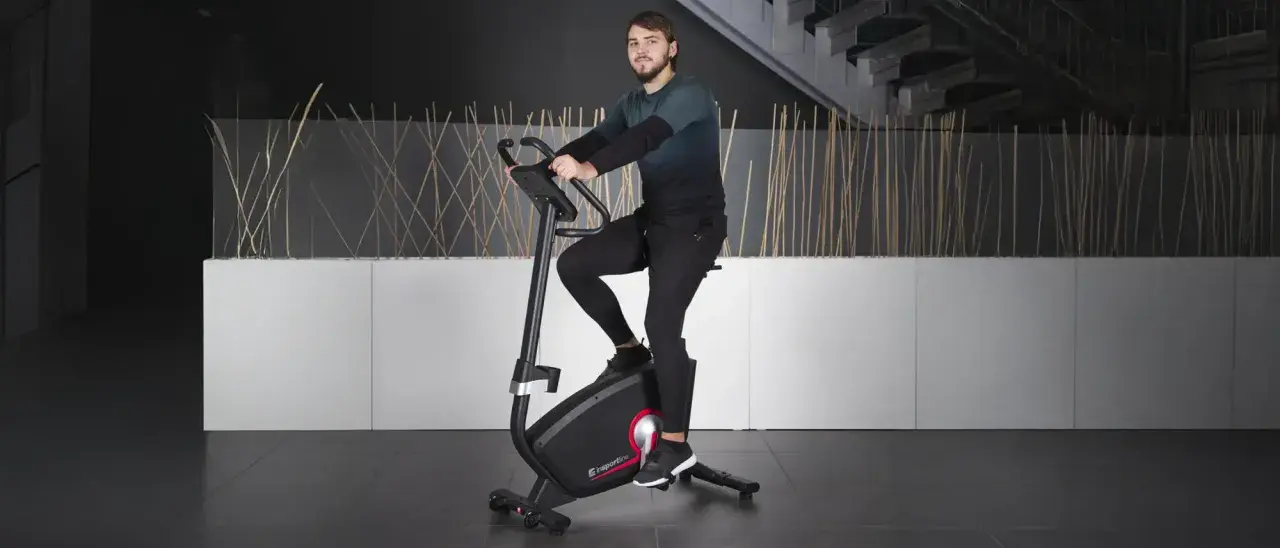 Mężczyzna ćwiczy na rowerze stacjonarnym, jednym z wielu rodzajów rowerów stacjonarnych dostępnych na rynku.