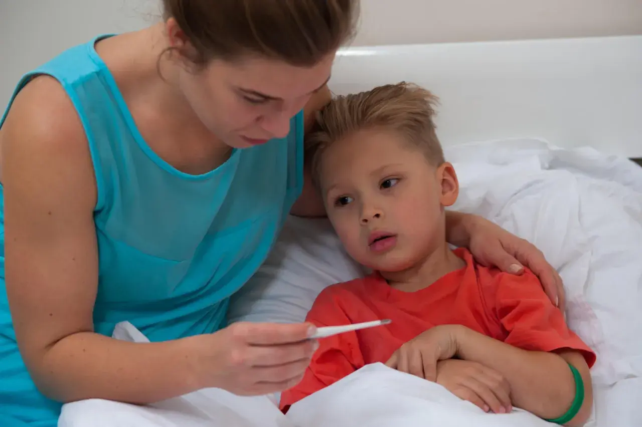 Mamma controlla la febbre al bambino, preoccupata per la quarta malattia.