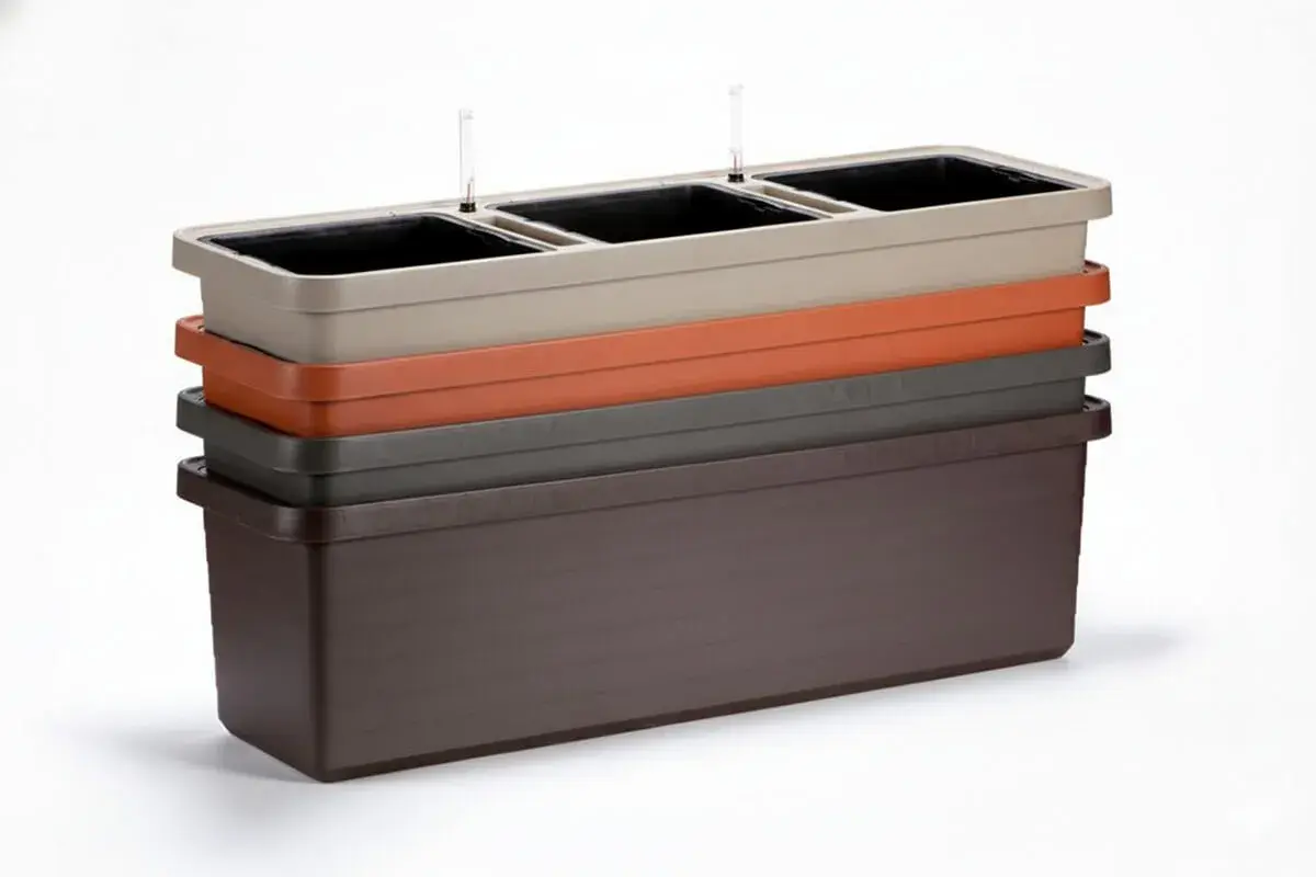 En stapel med fyra odlingslådor i plast i olika färger: ljusbeige, orange, grå och mörkbrun. De översta har vattenmätare.