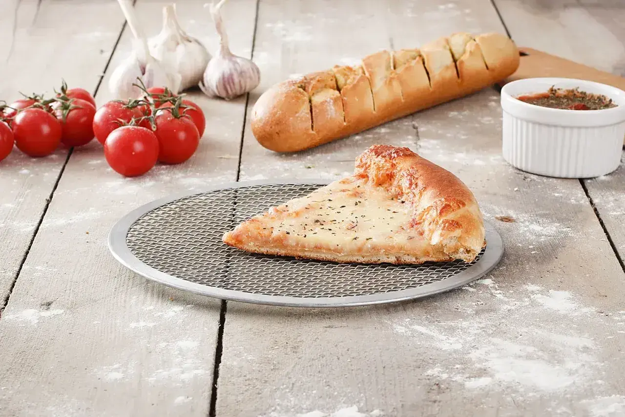 Idealnie wyrośnięte ciasto na pizzę, czosnek, pomidorki i bagietka czosnkowa.