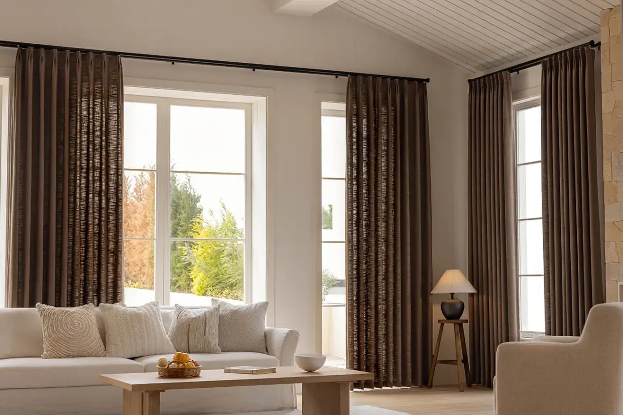 These rich brown curtains frame large windows, showing that curtains are far from out of style, adding warmth and texture to a modern living room.
