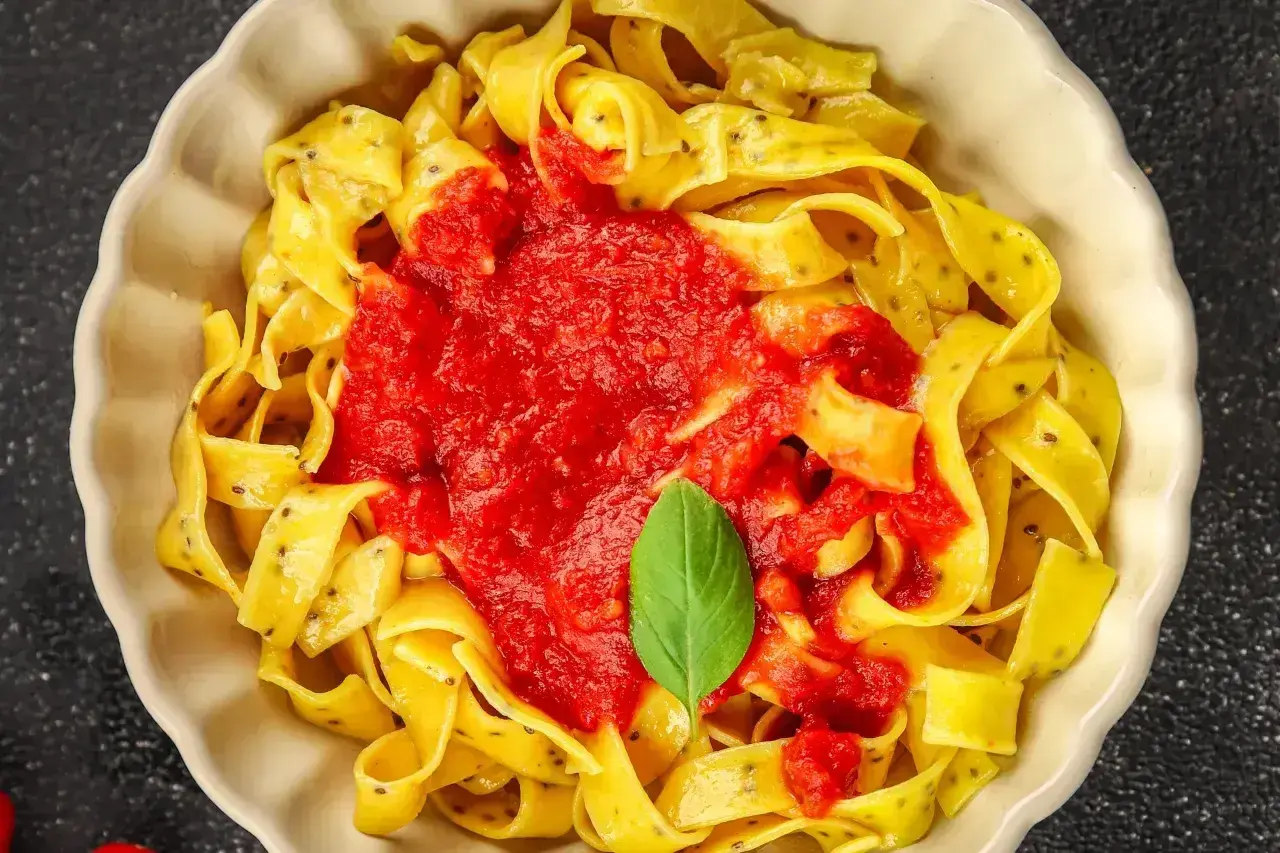 Pappardelle z sosem pomidorowym i bazylią. Różne rodzaje makaronu mogą być podawane na wiele sposobów.