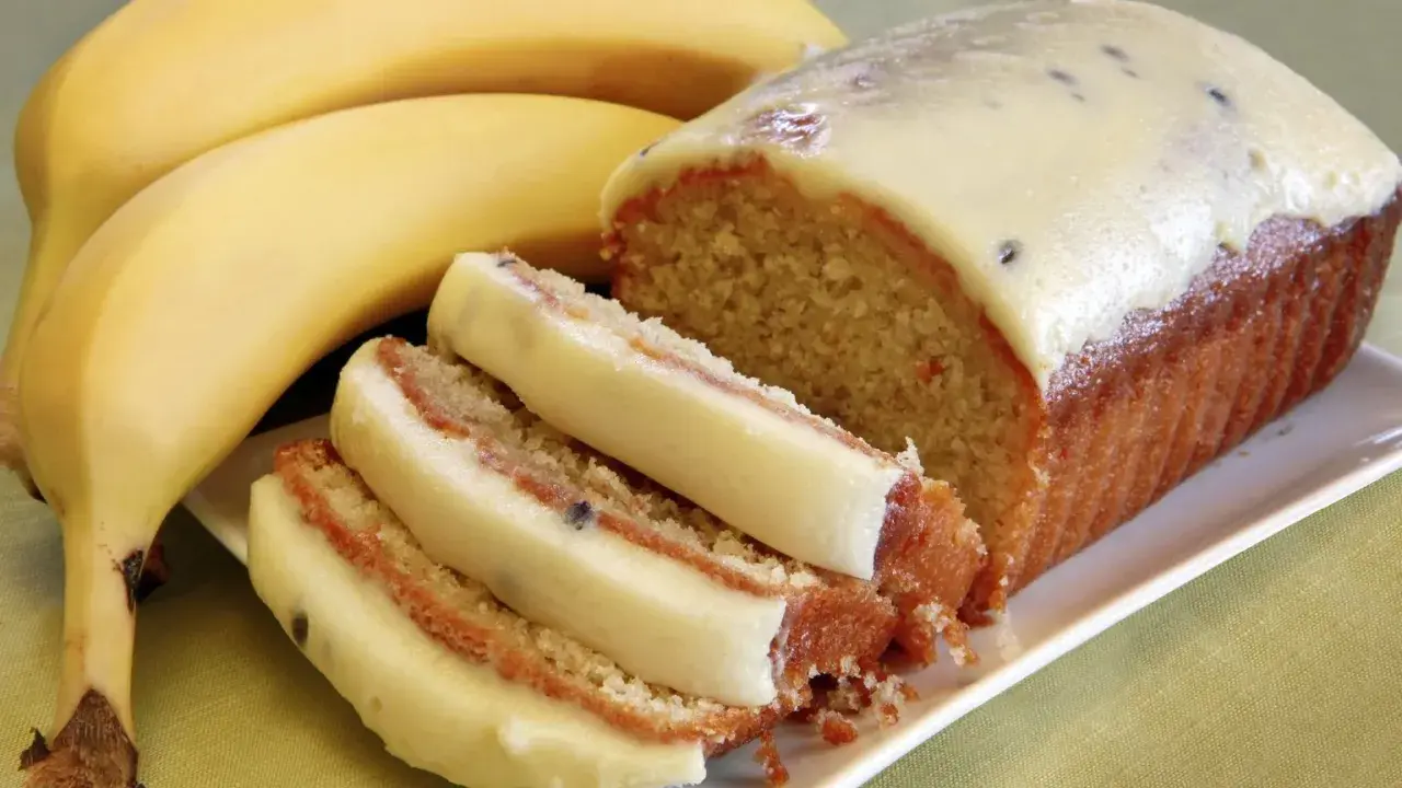 Szybkie ciasto z bananami i budyniem, z kremowym lukrem i kawałkami owoców. Idealne na deser.