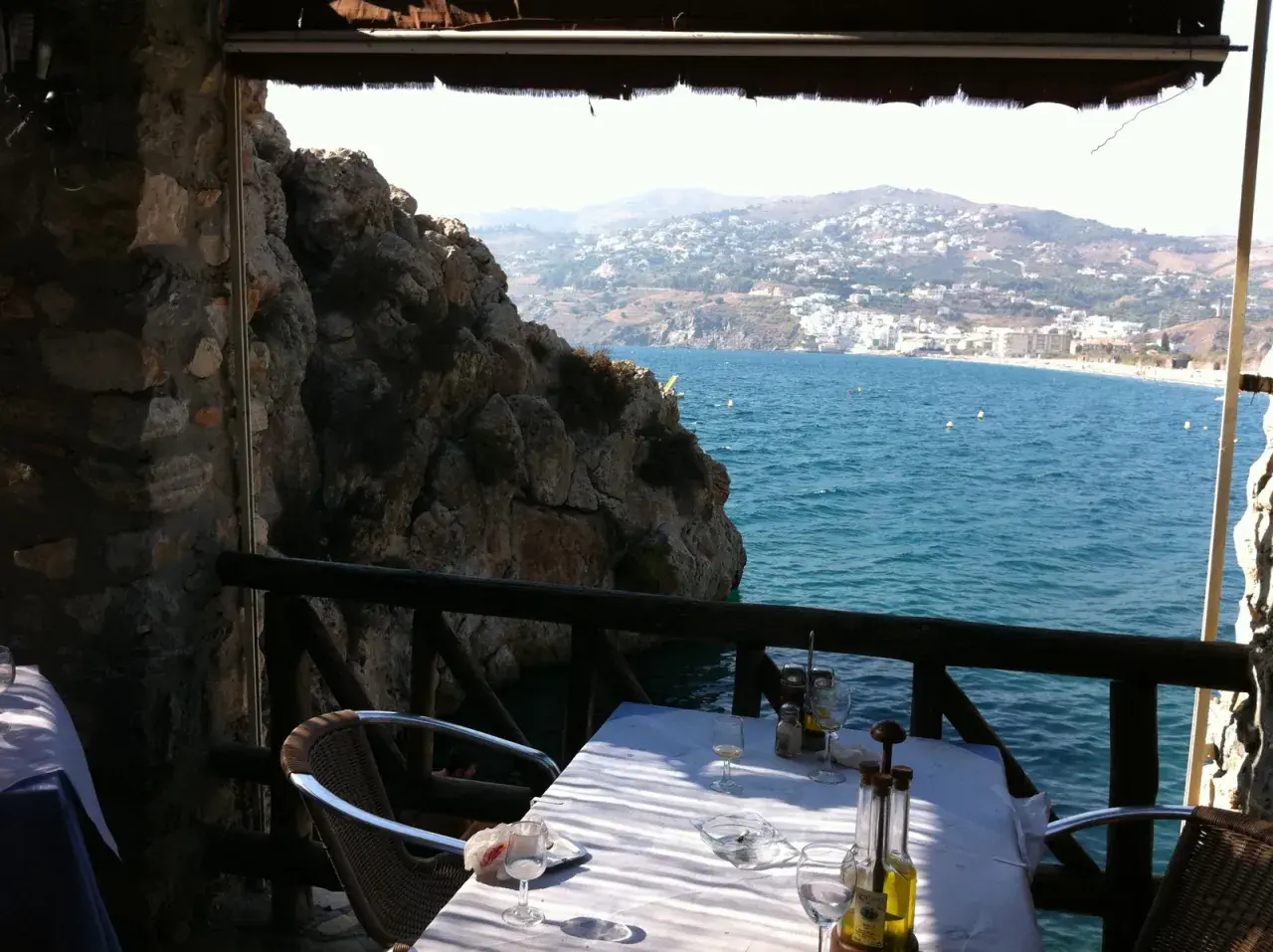 Mesa en restaurante el peñón con vistas al mar. Las reseñas destacan su ubicación privilegiada y la experiencia culinaria.