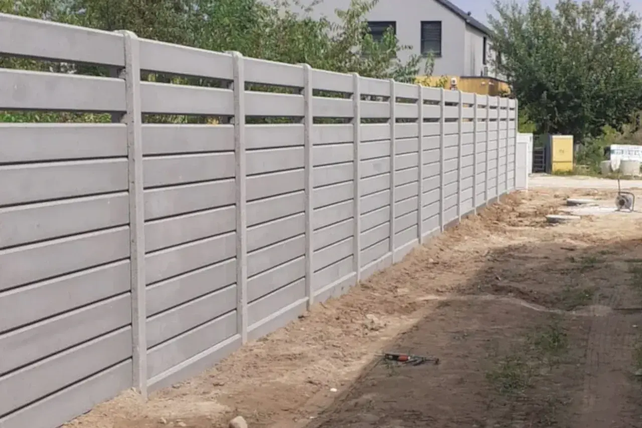Nowy, nowoczesny ogrodzenie systemowe betonowe tworzy solidną barierę.
