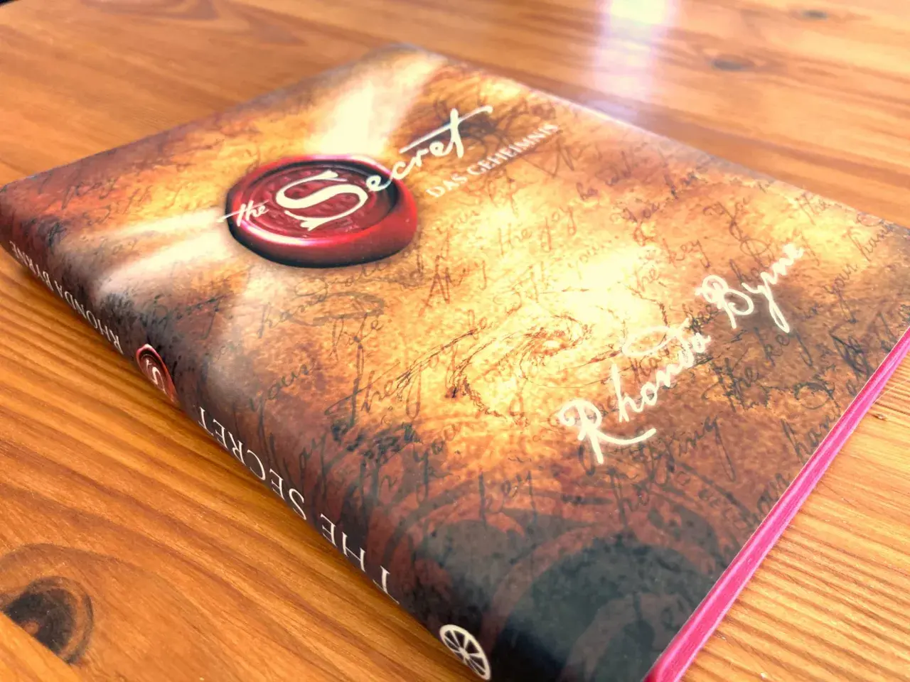 Das Buch "The Secret" von Rhonda Byrne, mit dem Siegel des Geheimnisses. Ein Wegweiser zu deinem Glück.