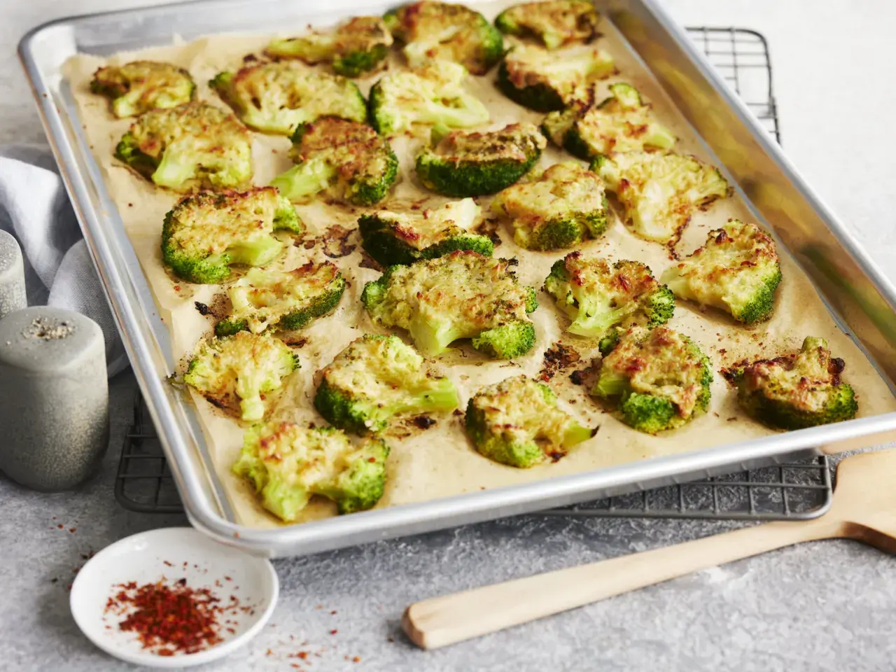 Gerösteter Brokkoli mit Käse auf einem Backblech. Perfekt zum **Brokkoli braten** für eine gesunde Beilage.