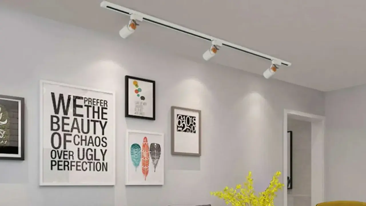 Aplique de pared con focos dirigibles ilumina un cuadro con tipografía moderna.