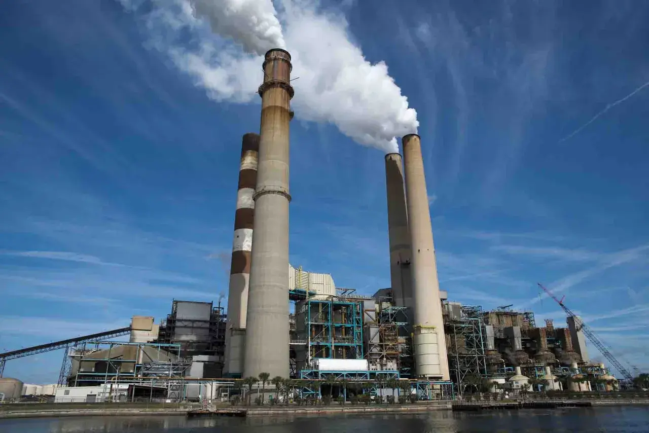 Chimeneas de una central eléctrica emiten vapor, un signo del calor industrial que genera energía.