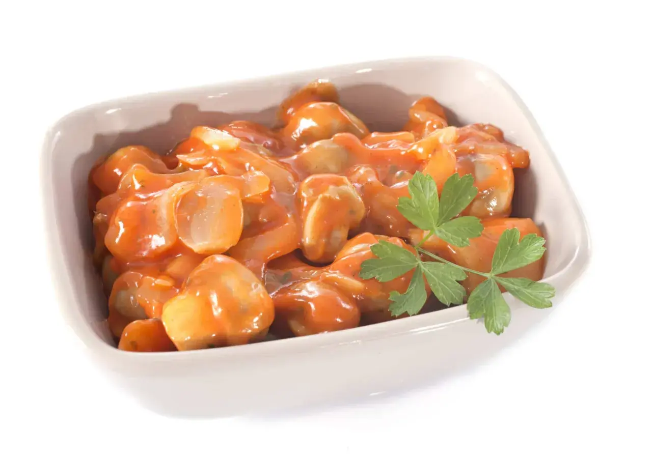 Un plat de champignons à la grecque, tendres et savoureux, baignant dans une sauce tomate onctueuse, garni d'une touche de persil frais.