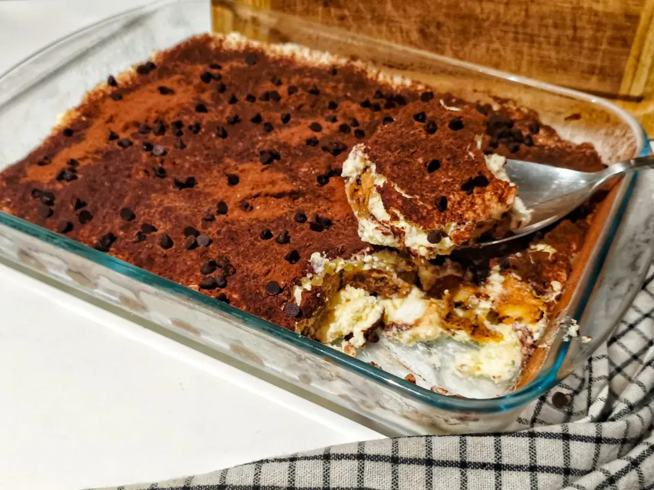 Un délicieux tiramisu ricotta, saupoudré de cacao et de pépites de chocolat, prêt à être dégusté.