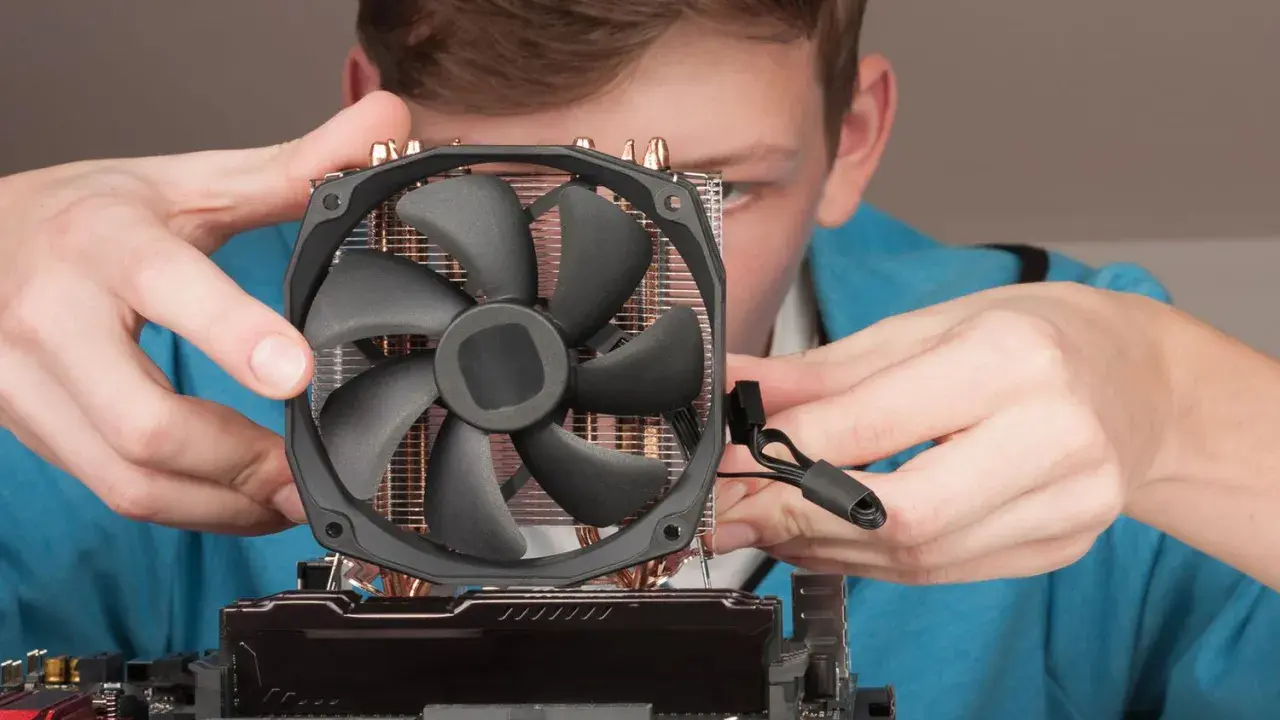Junge Person montiert CPU-Kühler. Möglicher Fehler: cpu fan speed detection error.