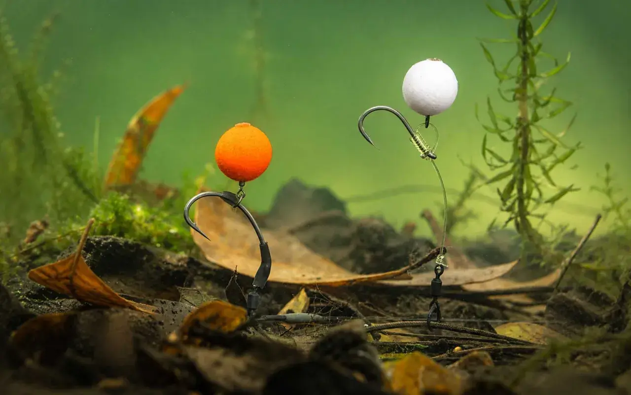 Zwei Pop-Up-Montagen mit orangefarbenen und weißen Kugeln, bereit für den Fang im Unterwasser-Dschungel.