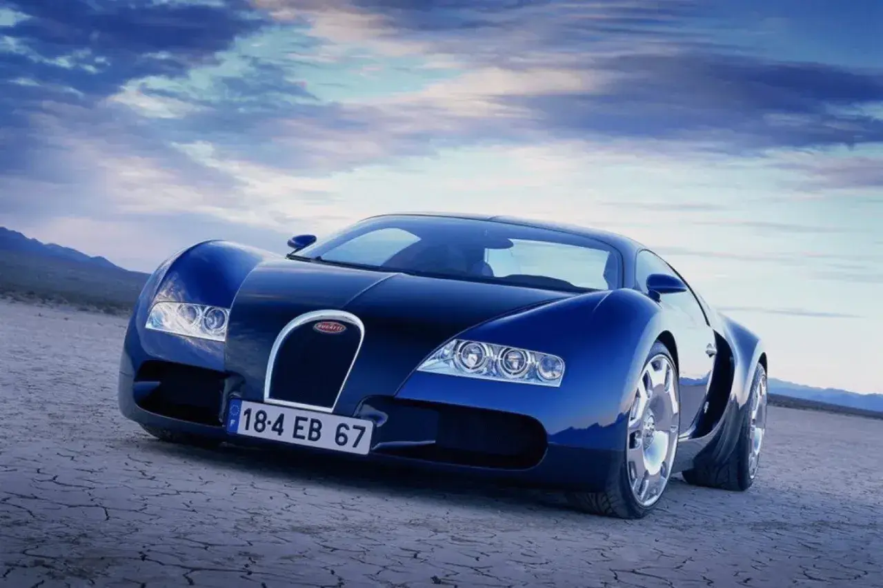 Niebieski Bugatti Veyron na pustynnym tle. Skąd pochodzi ten legendarny samochód? Z Francji, z Alzacji, gdzie narodził się Ettore Bugatti.