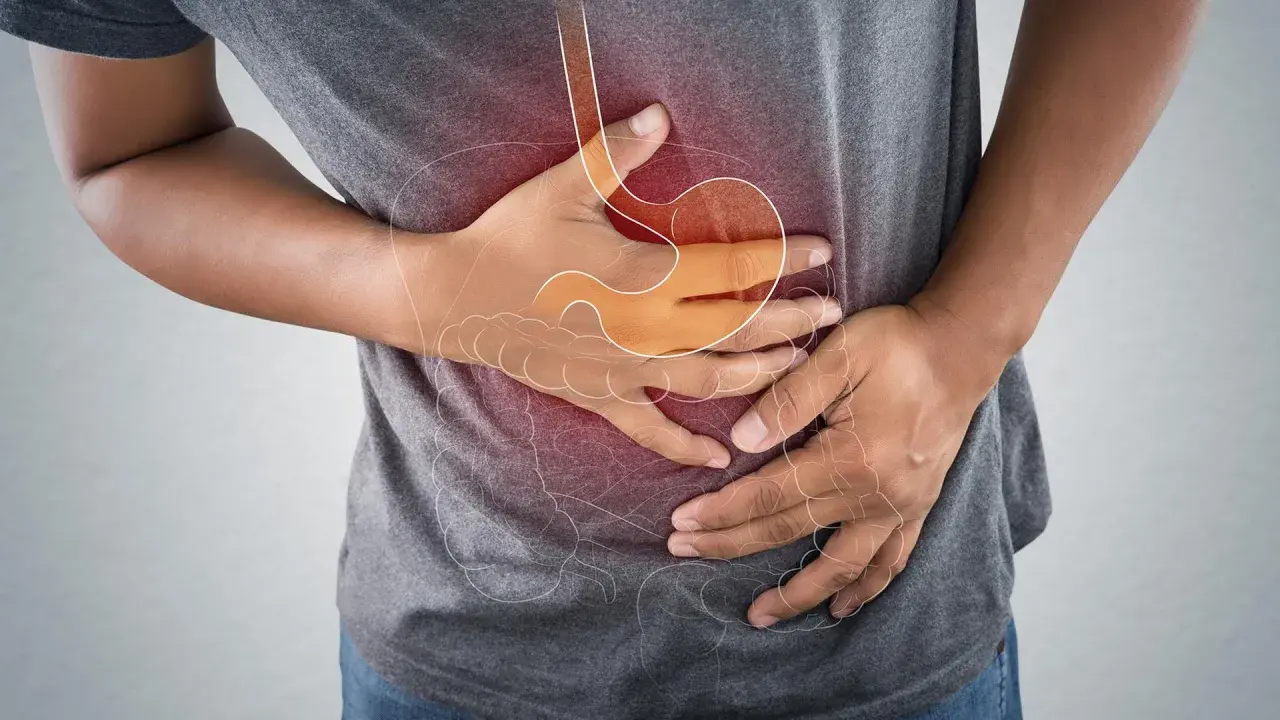 Mann hält sich den Bauch wegen eines akuten Abdomens. Die Grafik zeigt den Magen und Darm.