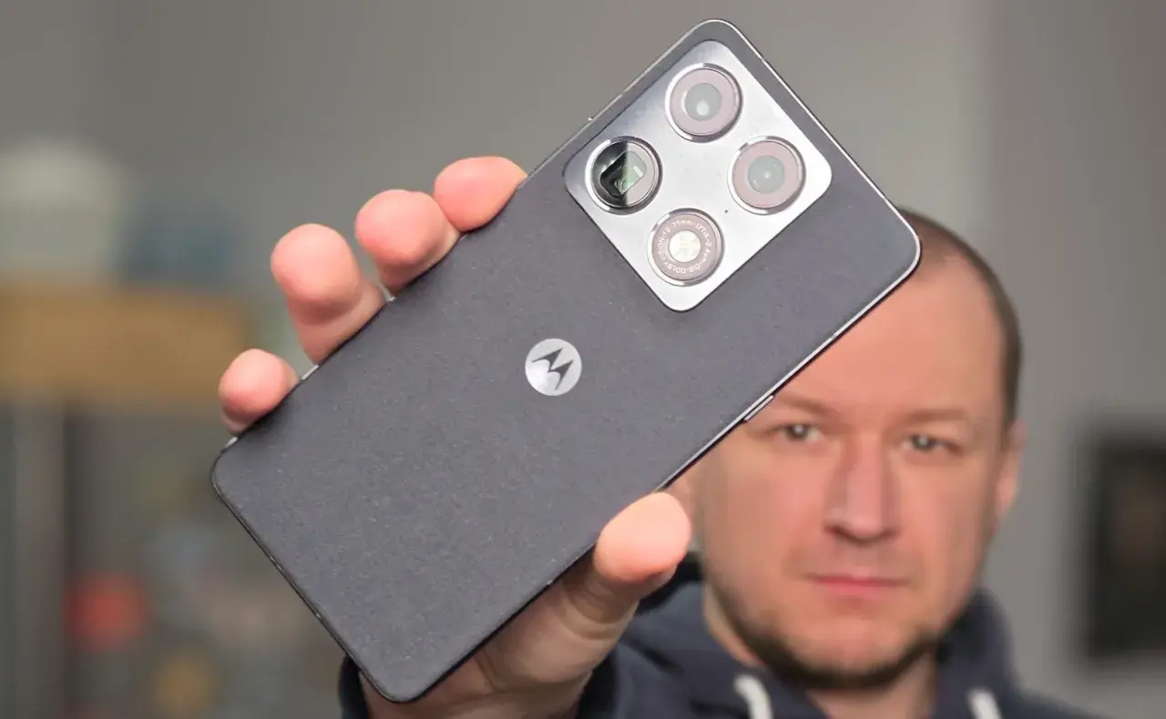 Mężczyzna prezentuje smartfon Motorola z charakterystycznym logo i modułem aparatów.