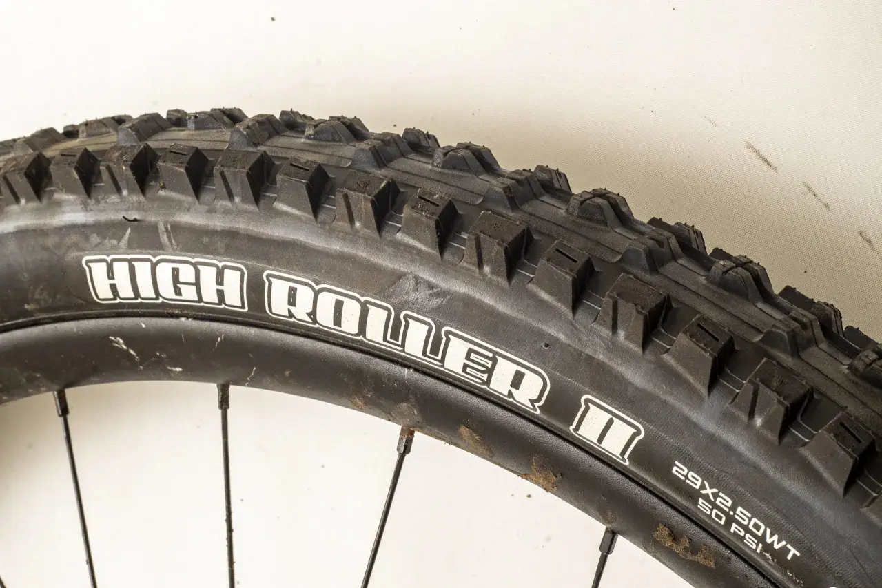 Close-up of a Maxxis High Roller II tire, ready for a review. Its aggressive tread promises excellent grip on challenging trails.