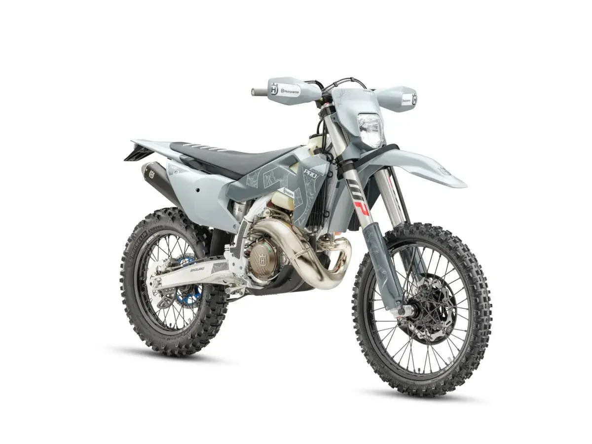 Szary motocykl Husqvarna z oponami terenowymi na białym tle.