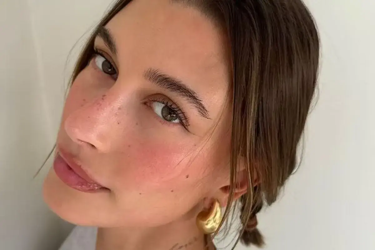 En närbild på en kvinna som har valt att applicera rouge för en naturlig, rosig look.