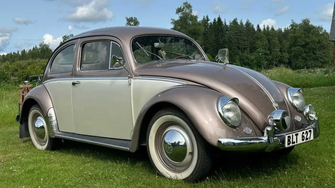 En tvåfärgad bubblan bil står på en gräsmatta.