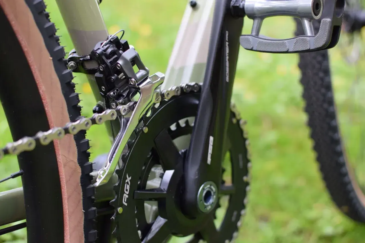 Zbliżenie na rower, widoczny mechanizm korbowy, łańcuch i przerzutka. Czas na czyszczenie łańcucha rowerowego, by jazda była płynna.