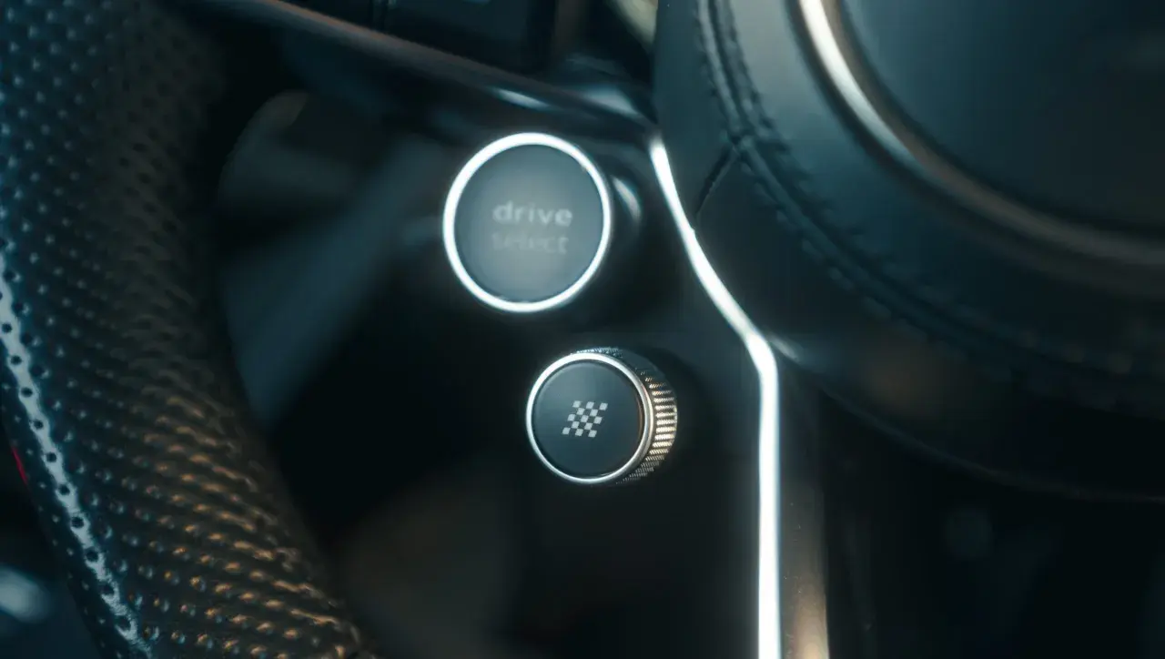 Przycisk "drive select" i przycisk z szachownicą, gotowe do aktywacji launch control.