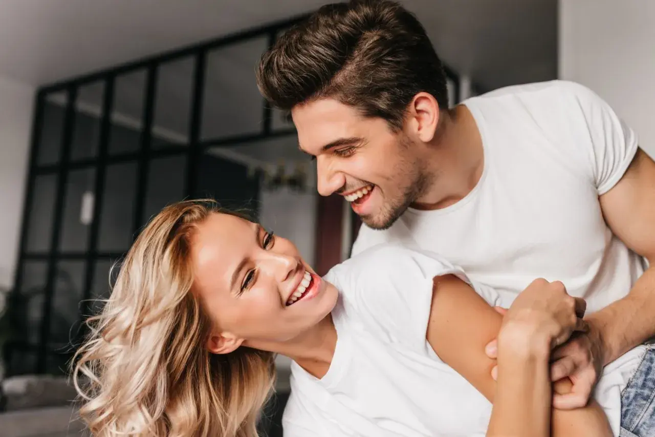 Uśmiechnięta para, która wyraźnie się sobą cieszy. To właśnie flirtowanie co to – radość i wzajemne przyciąganie.