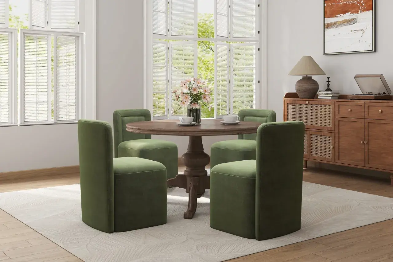Four green chairs with plush, straight backs surround a round wooden table, showcasing modern types of chair backs.