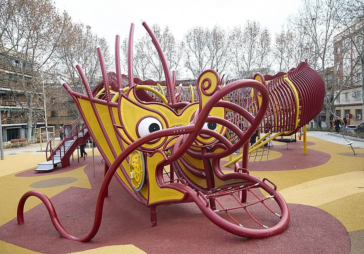 Un parque infantil con forma de dragón amarillo y rojo en Usera. ¡Un lugar genial que ver en Usera para los niños!