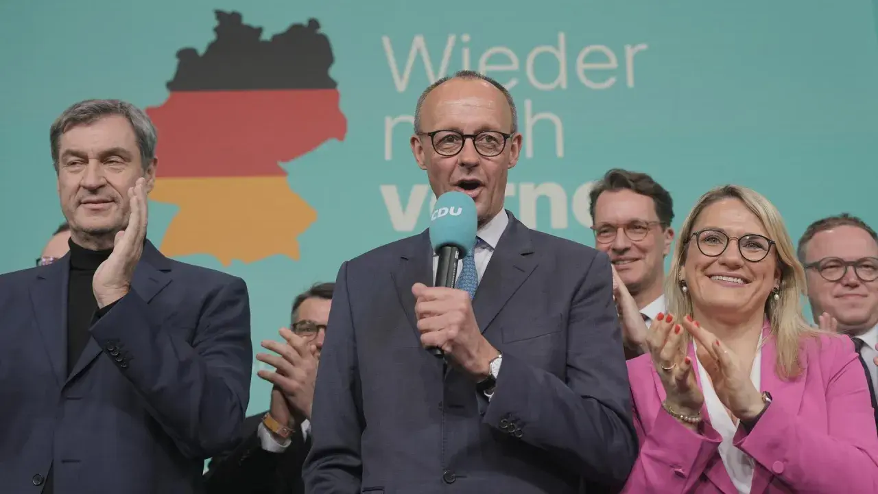 Friedrich Merz spricht ins Mikrofon, flankiert von wichtigen Politikern der CDU wie Markus Söder und Andrea Lindholz.