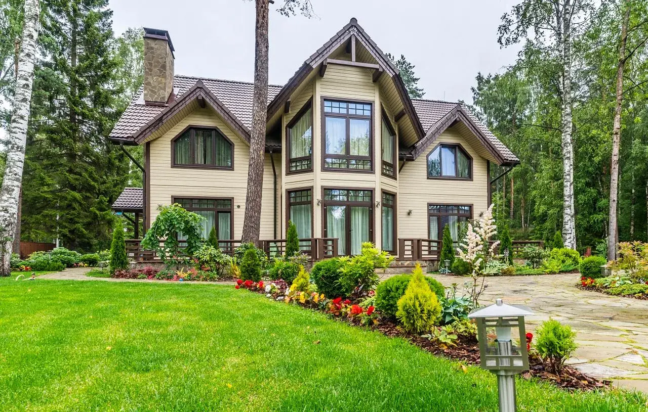 Elegantes casas canadienses rodeadas de exuberante vegetación y un jardín cuidado.