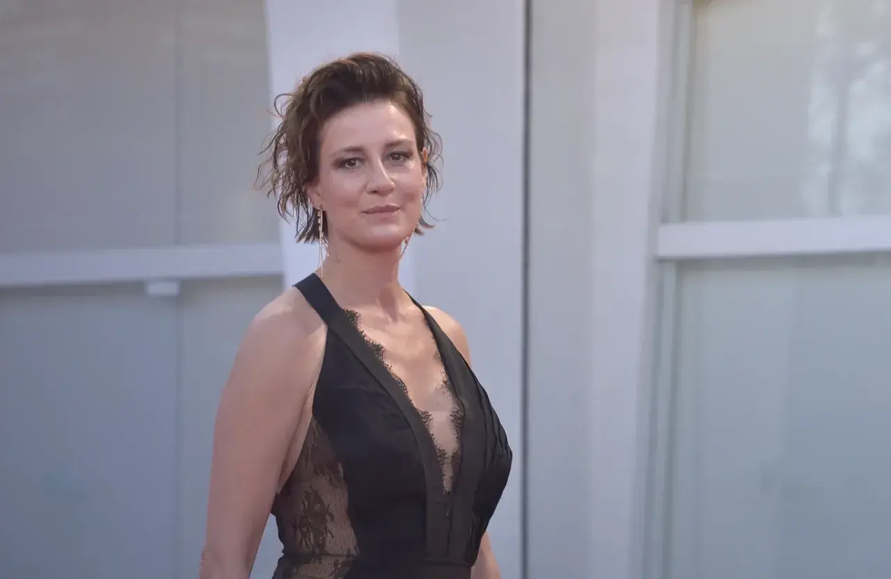 Maja Ostaszewska w czarnej, koronkowej sukni na czerwonym dywanie. Aktorka znana z wielu polskich filmów.