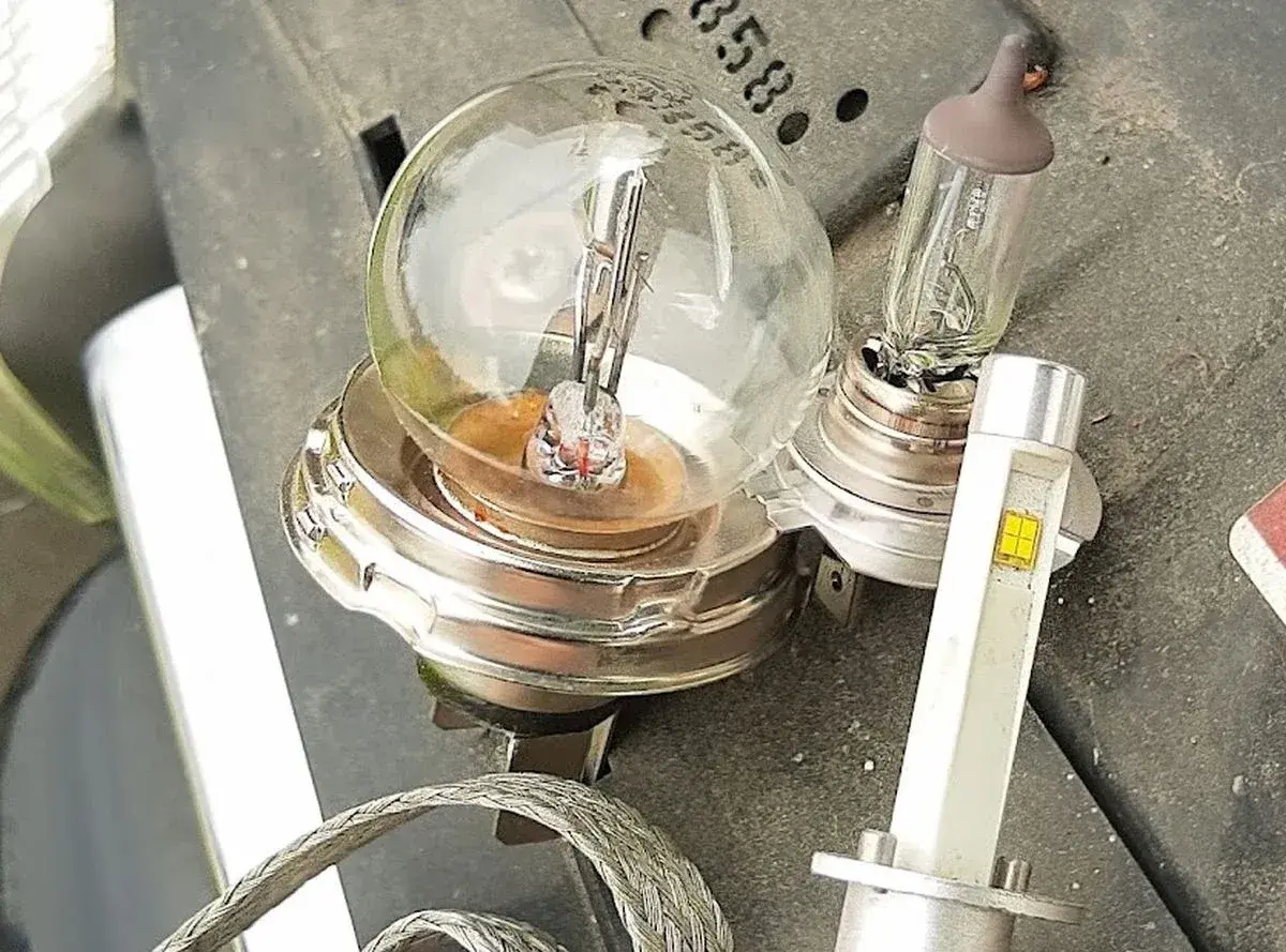 Stare żarówki słabo świecą w domu, obok nowoczesna lampa LED.