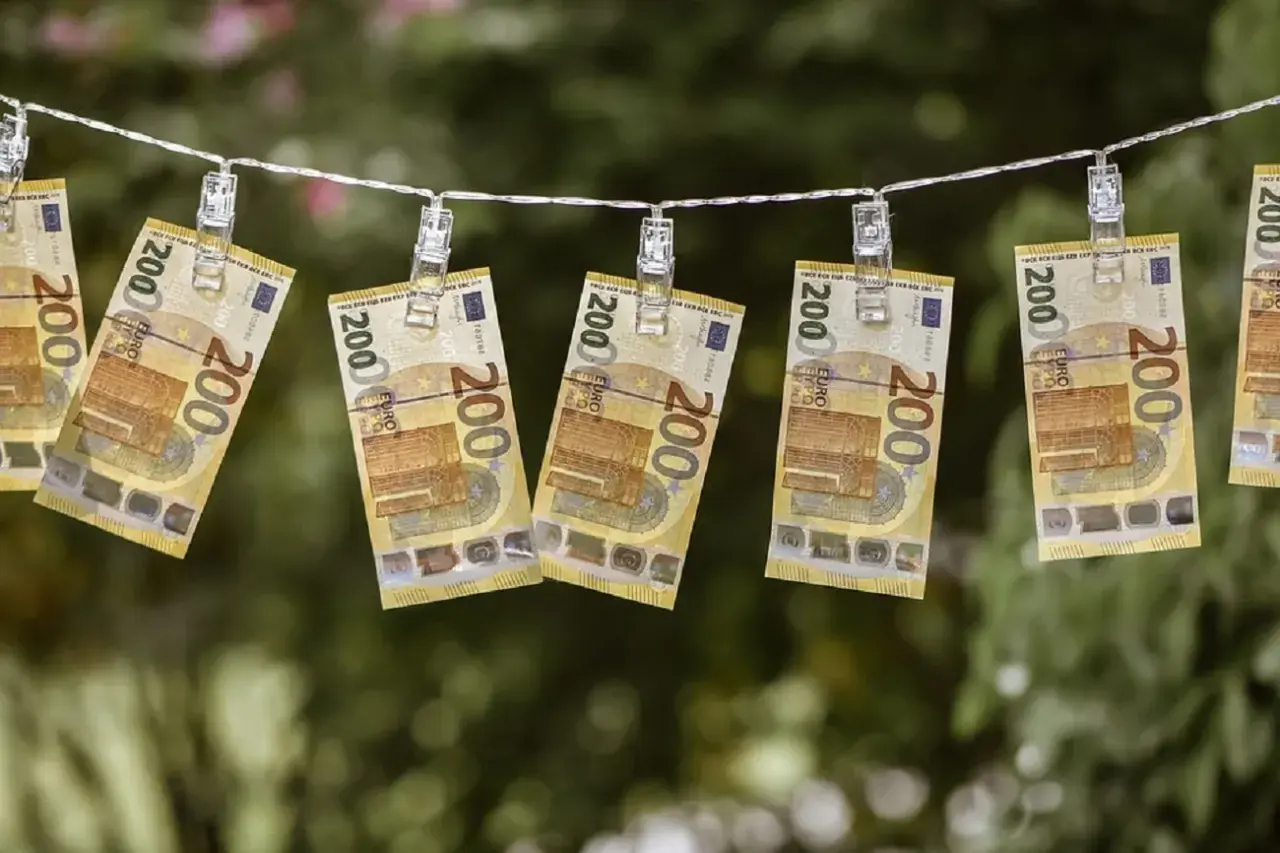 Banconote da 200 euro stese ad asciugare, un modo visivo per chiedersi quanto costa una busta paga.
