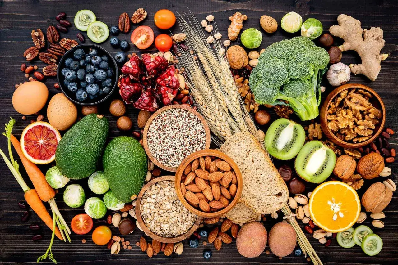 Assortiment de fruits, légumes, noix et céréales, des aliments riches en fibres insolubles pour une alimentation équilibrée.