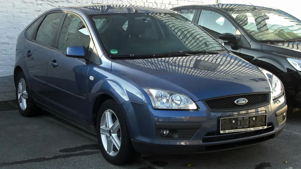 Ford Focus azul con posible fallo sistema motor. Aparcado junto a otro coche negro.