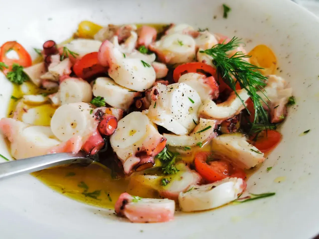Ein köstlicher **pulpo salat original** mit zarten Oktopus-Stücken, Tomaten und frischen Kräutern in Olivenöl.
