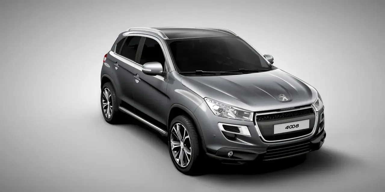 Szary crossover Peugeot 4008 z czarnym dachem i srebrnymi relingami, widok z przodu i z boku.