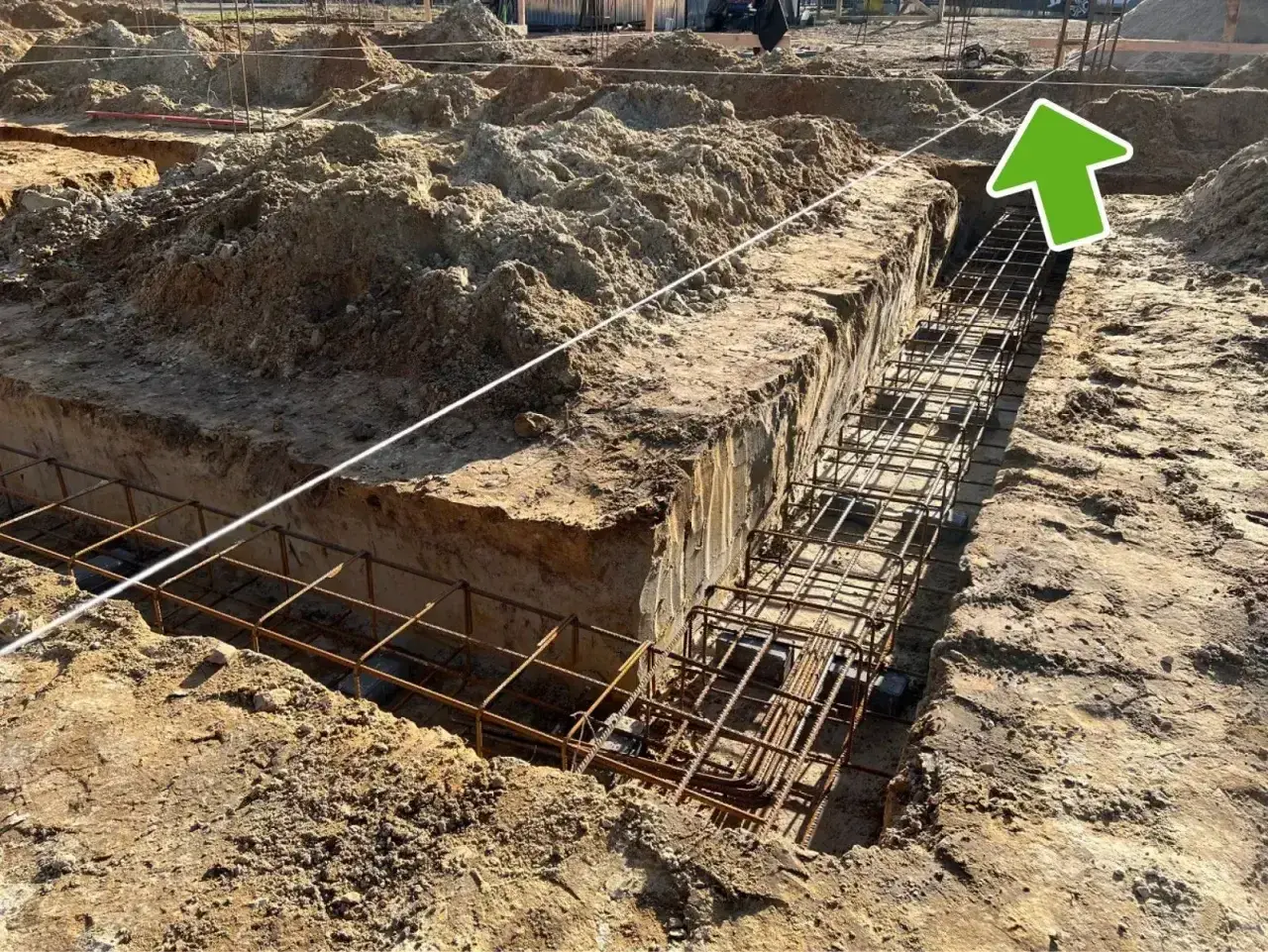 Wytyczenie budynku: zbrojenie ławy fundamentowej w wykopie. Widać sznur geodezyjny do precyzyjnego wyznaczenia.