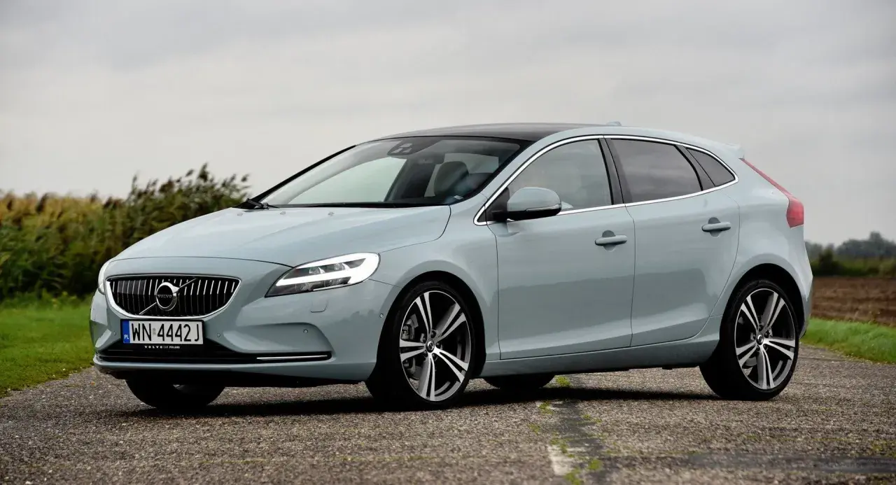 Jasnoszary Volvo V40 na drodze, z widocznymi felgami i oponami. Idealny rozmiar opon dla tego modelu.
